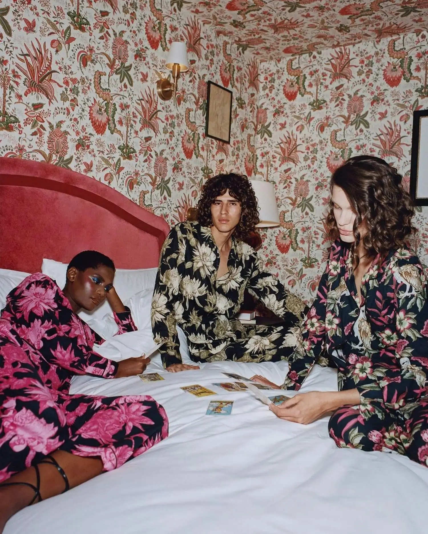 a group of women in floral pajamas sitting on a bed