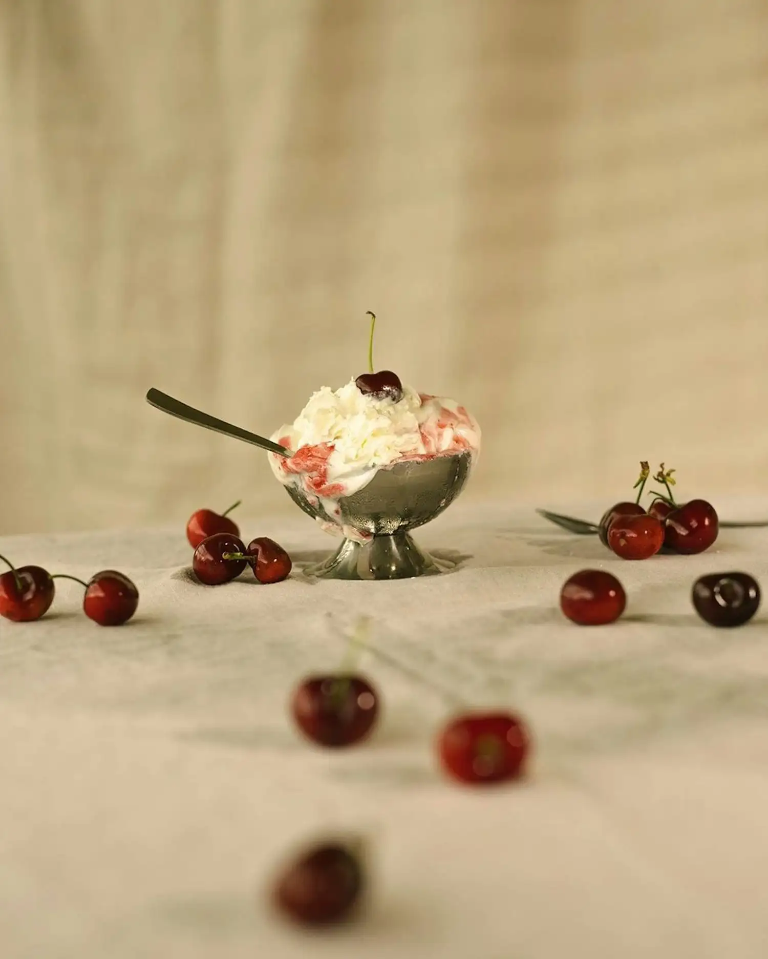 a bowl of whipped cream and cherries on a table