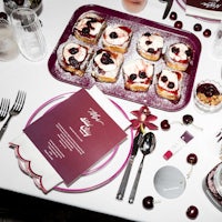 a table is set with a plate of food and a glass of wine